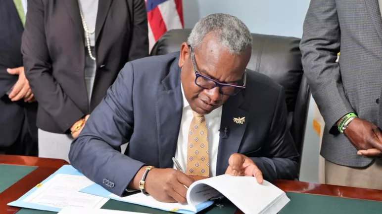 Photo du gouverneur signant le décret