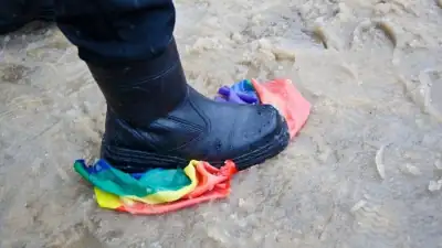 Une botte écrasant un drapeau arc-en-ciel